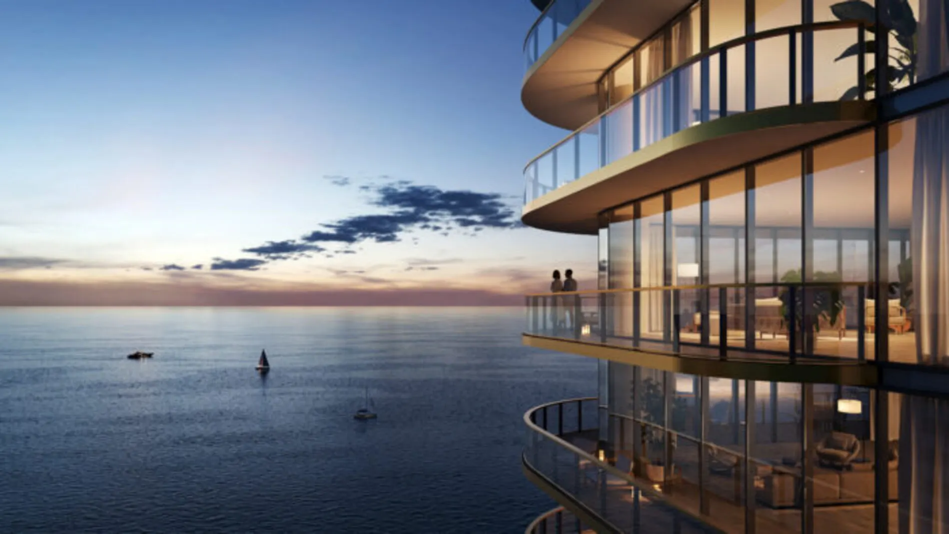 Luxury oceanfront condo tower at sunset with glass balconies overlooking the Atlantic Ocean, part of the Waldorf Astoria Pompano Beach residences.